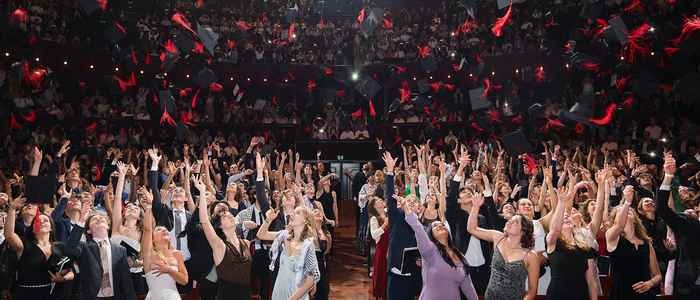 AUC students throwing hats in the air at Graduation 2024